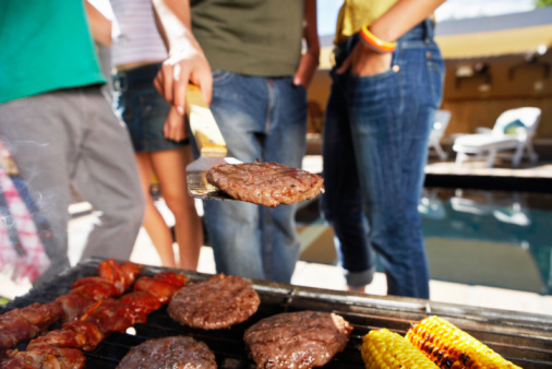 People grilling food outdoors