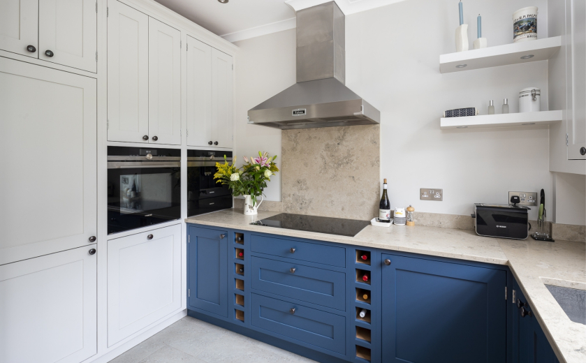 blue kitchen with beige limestone kitchen worktops and splashback