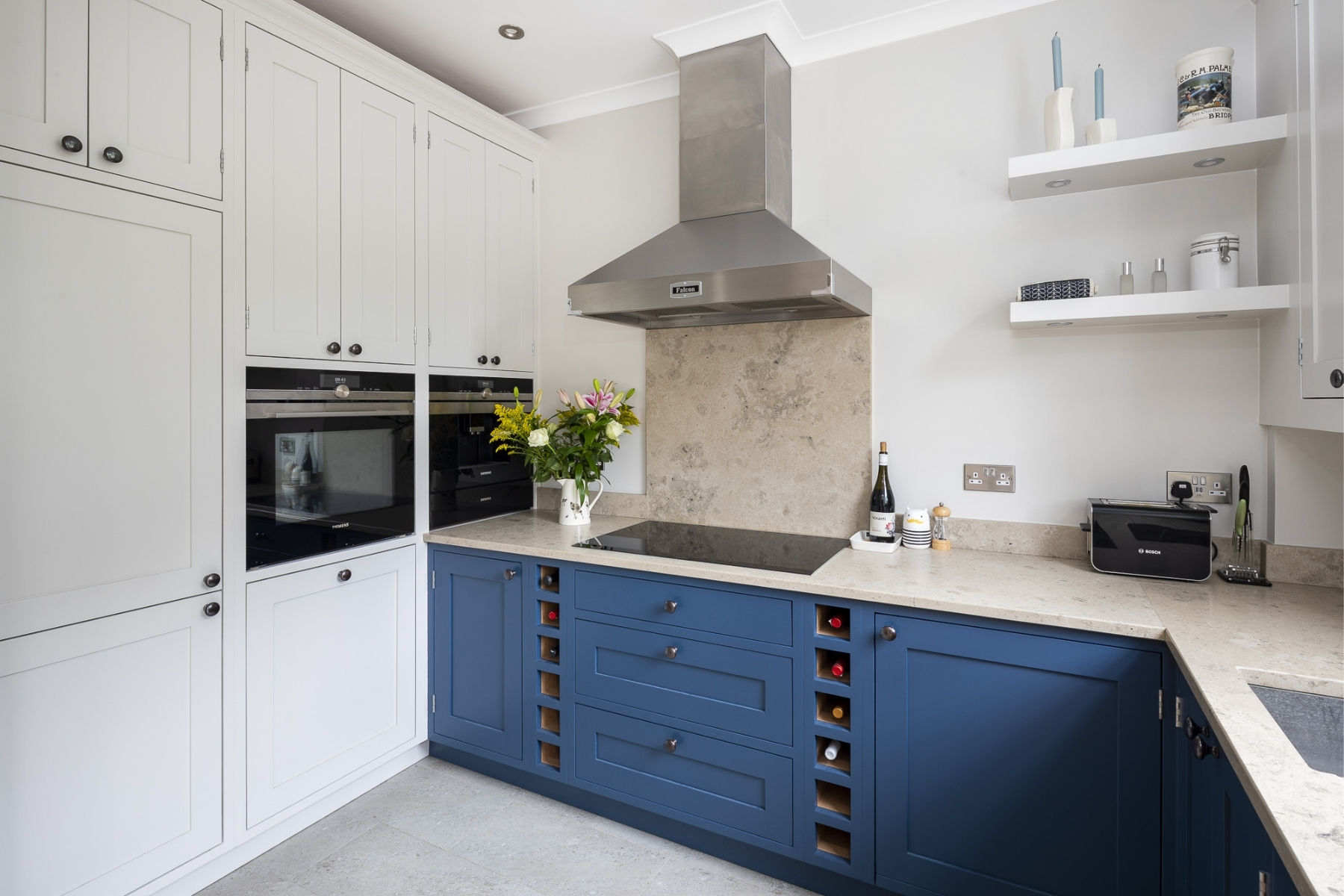 blue kitchen with beige limestone kitchen worktops and splashback
