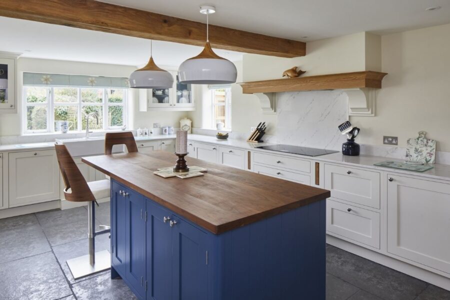 white and blue kitchen cabinets with marble-effect quartz worktops, supplied by Landford Stone, Wiltshire